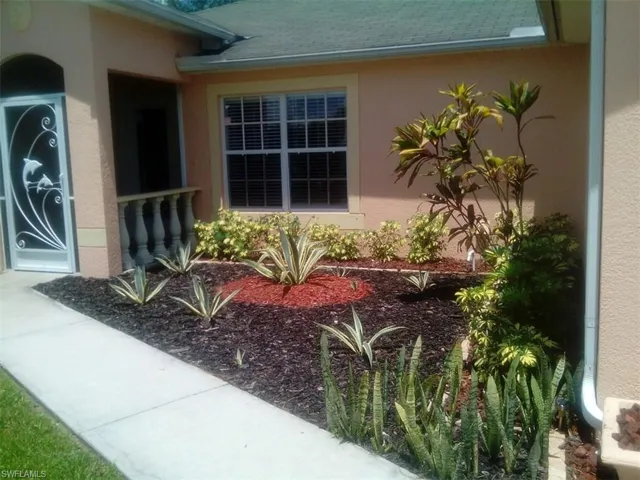 Property entrance featuring stucco siding and a shingled roof
