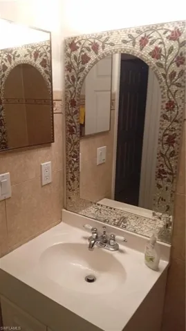 Bathroom featuring tile walls and vanity