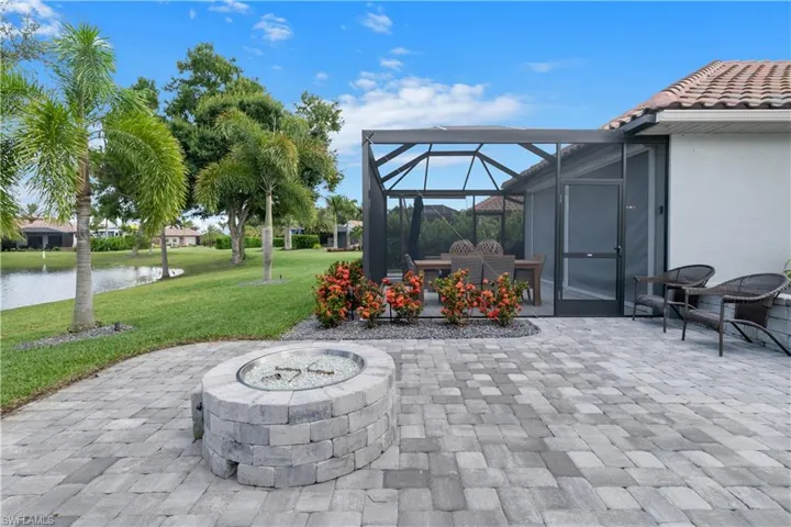 View of terrace featuring a lanai, a fire pit, and a water view