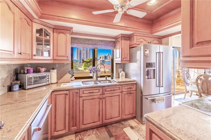 Kitchen featuring stainless steel appliances, ceiling fan, crown molding, and sink