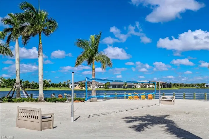 white sand beach overlooking water with beach volleyball