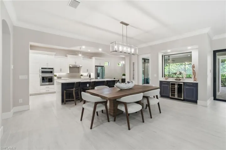 Dining space featuring crown molding, wine cooler, and recessed lighting