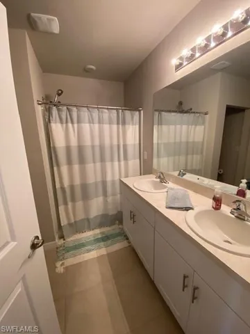 Kitchen with white cabinetry, appliances with stainless steel finishes, light tile patterned floors, a center island with sink, and recessed lighting