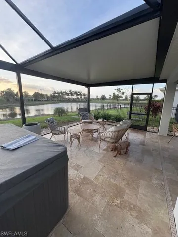 Living area with a stone fireplace and light tile patterned floors