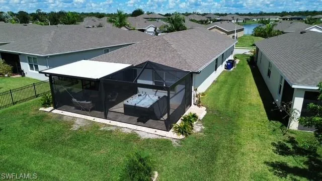 Back of house with a water view, a sunroom, and a patio area