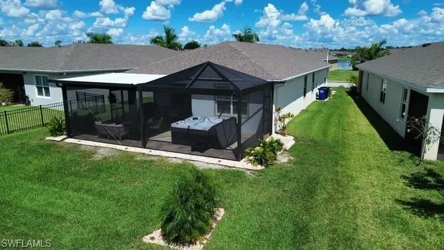 Rear view of property featuring a patio area, a sunroom, and stucco siding
