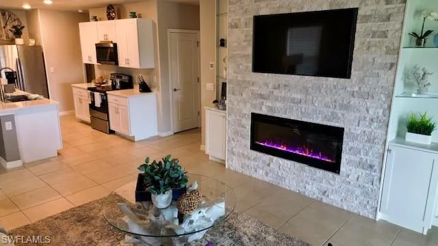 Laundry area featuring washing machine and clothes dryer, cabinet space, and light tile patterned floors
