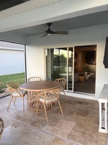 Tiled living room featuring a ceiling fan and baseboards