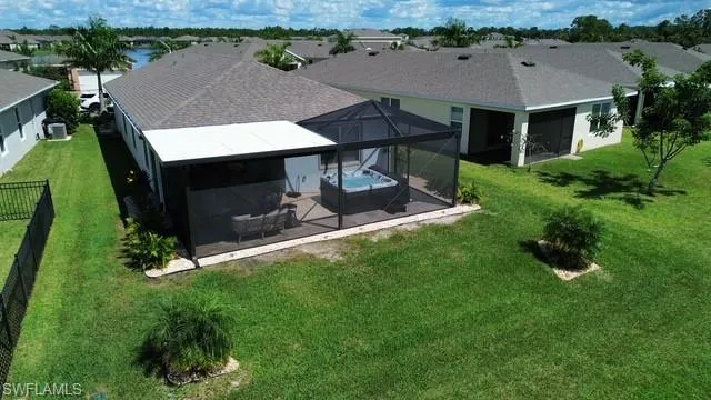 View of patio featuring a sunroom, a hot tub, a lanai, and ceiling fan