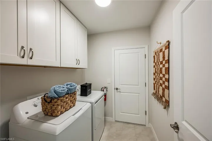 Laundry room featuring washing machine and clothes dryer and cabinet space