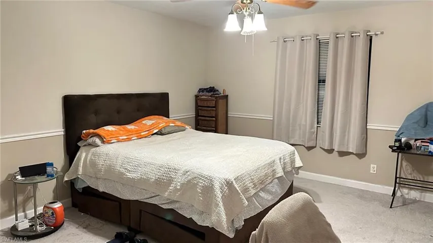 Carpeted bedroom featuring baseboards and ceiling fan