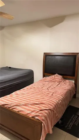 Bedroom with light tile patterned floors and a ceiling fan