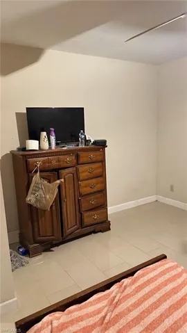 Bedroom with light tile patterned floors and a ceiling fan