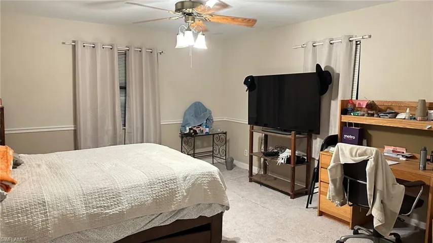 Bedroom featuring carpet flooring, ceiling fan, and an office area
