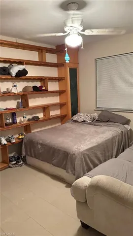Bedroom with light tile patterned flooring and a ceiling fan