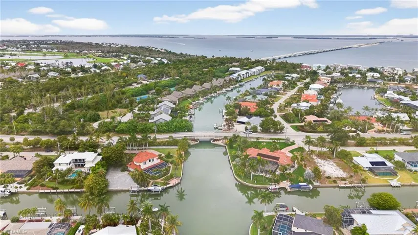 Aerial view of property and surrounding area with nearby suburban area and a large body of water