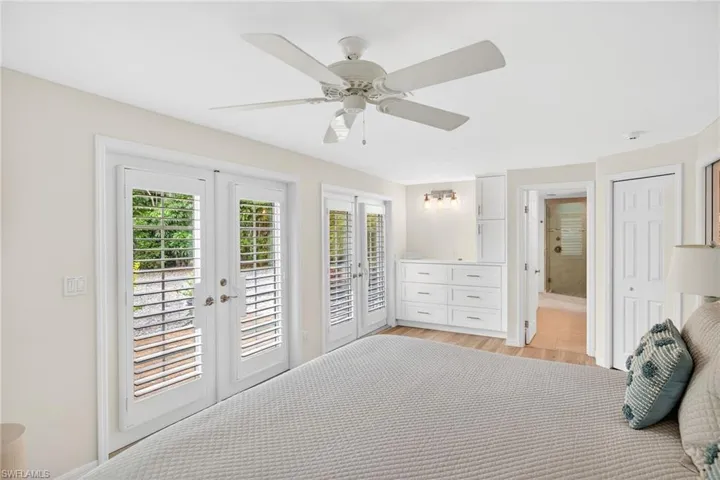 Primary Bedroom featuring access to outside, french doors, ceiling fan, and ensuite bath