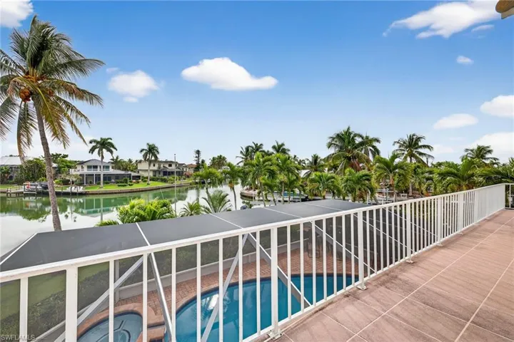 Balcony with view of pool, a water view, and a jacuzzi
