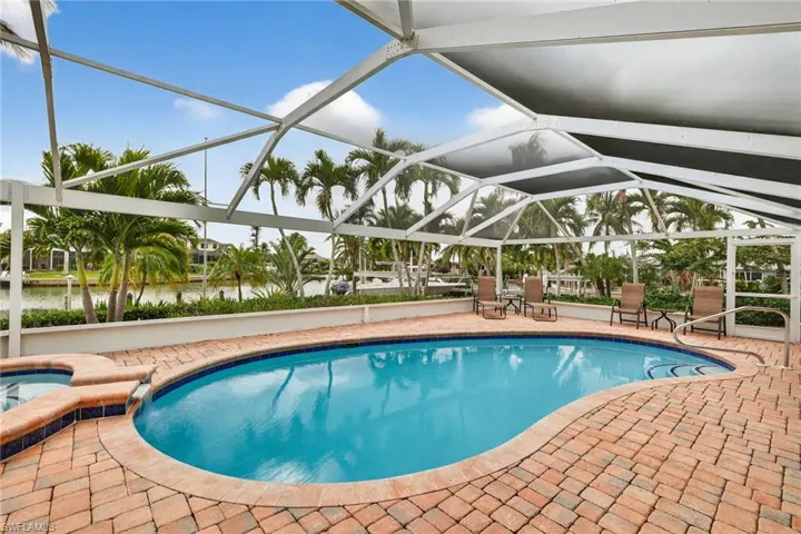 View of swimming pool featuring a lanai, a patio, a sunroom, and a pool with connected hot tub