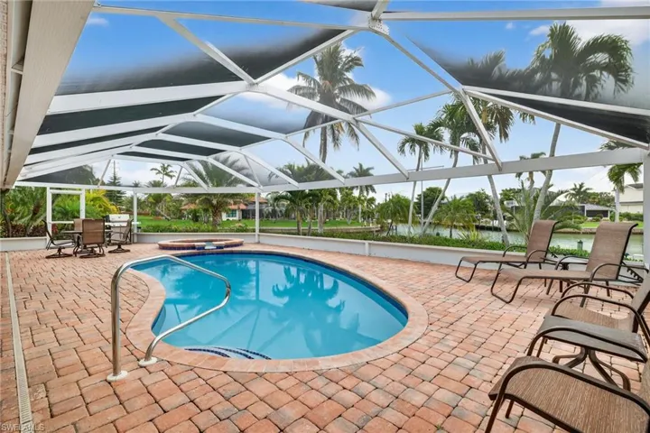 View of pool with a patio area, a lanai, a sunroom, and a pool with connected hot tub