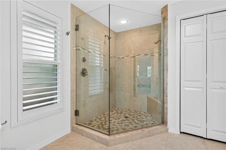 Primary Bathroom featuring a shower stall, a closet, and tile patterned floors