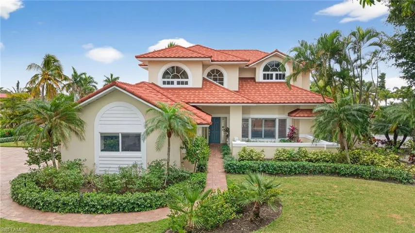 Mediterranean / spanish home with stucco siding, a front yard, a tiled roof, and covered porch