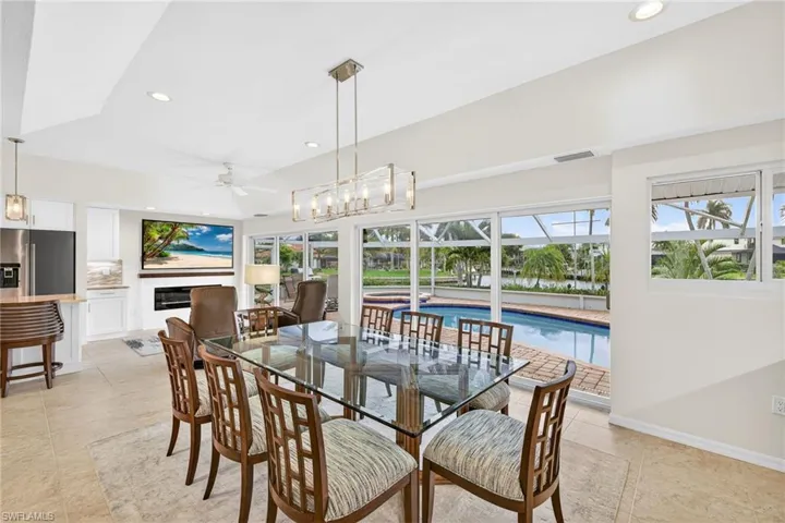 Dining space with recessed lighting and a glass covered fireplace