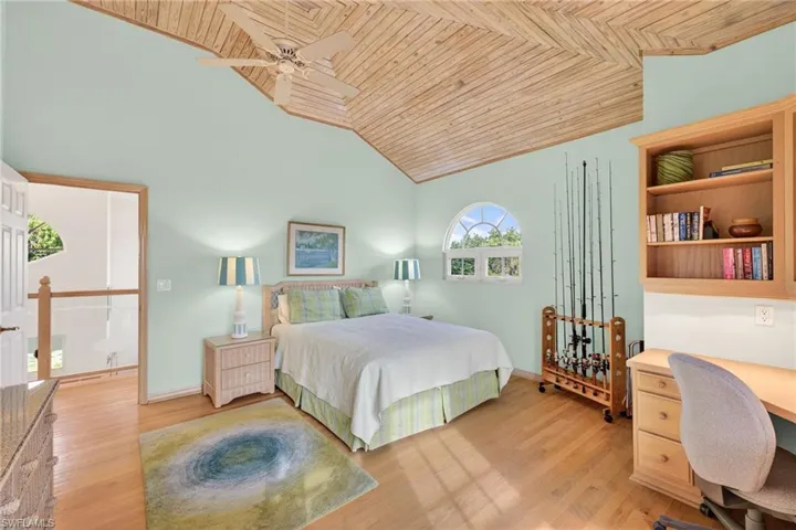 Bedroom featuring wooden ceiling, light wood-style floors, an office area, ceiling fan, and high vaulted ceiling
