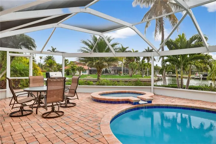 View of swimming pool featuring a lanai, a sunroom, a patio, and a pool with connected hot tub