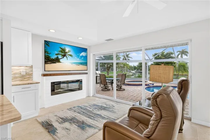 Family room with recessed lighting, a sunroom, a glass covered fireplace, ceiling fan, and light tile patterned floors