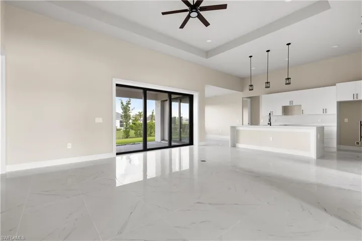 Unfurnished living room featuring ceiling fan, light marble finish floors, a towering ceiling, and recessed lighting