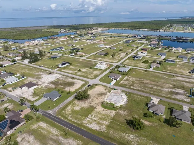 Aerial view of property and surrounding area with nearby suburban area