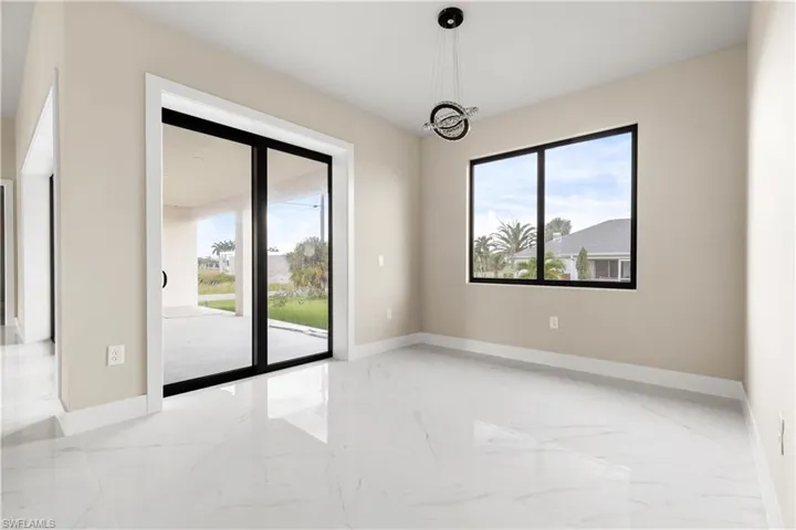 Unfurnished room with light marble finish floors and healthy amount of natural light