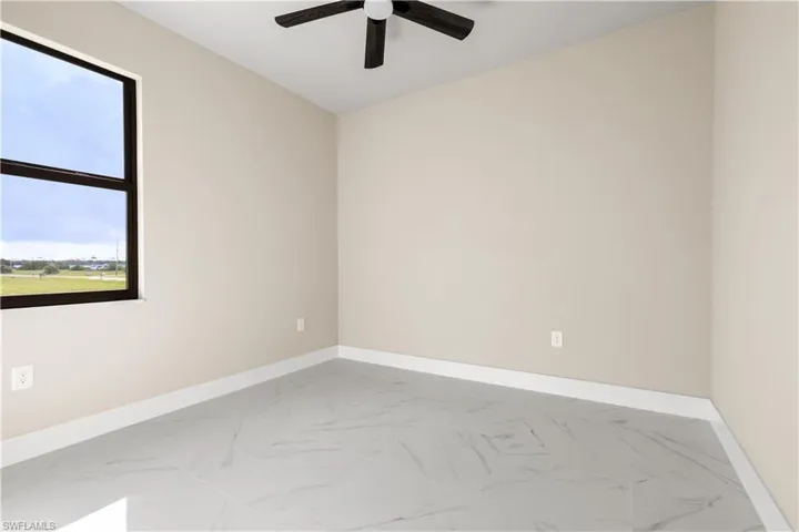 Unfurnished room featuring ceiling fan and marble finish flooring