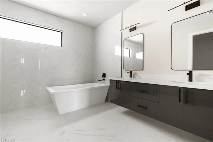 Full bathroom with double vanity, a freestanding tub, and marble tiled floors