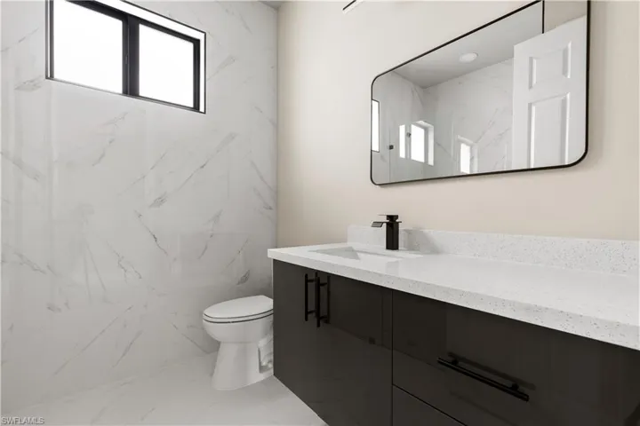 Bathroom with marble finish floors and vanity