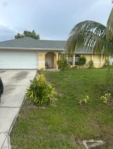 View of front of house with stucco siding, an attached garage, concrete driveway, roof with shingles, and a front yard