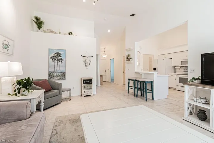 Tiled living room with high vaulted ceiling