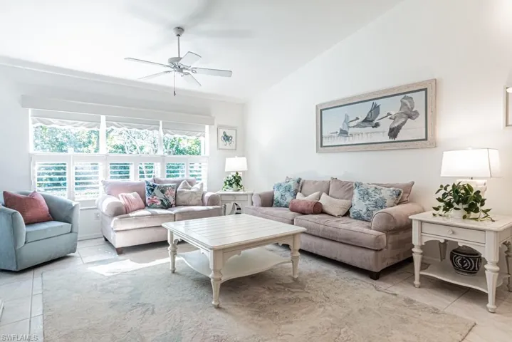 Tiled living room with vaulted ceiling and ceiling fan