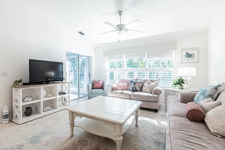 Living room featuring light colored carpet and ceiling fan
