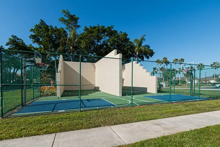 View of basketball court with a lawn