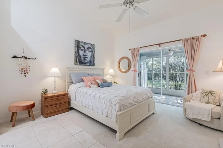 Master Bedroom with access to exterior, light colored carpet, ceiling fan, and lofted ceiling