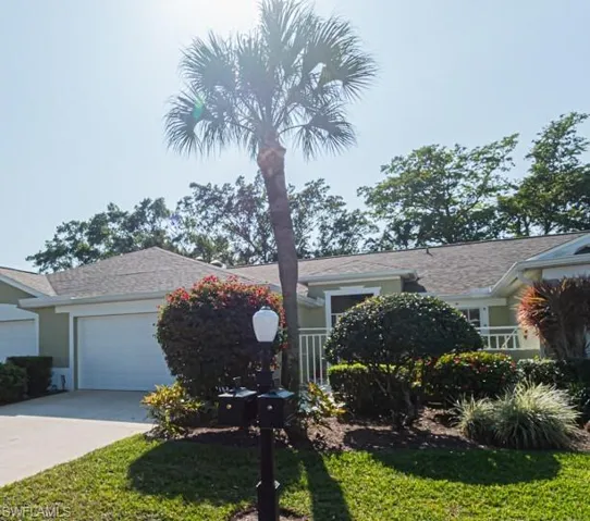 View of front facade featuring a front yard and a garage