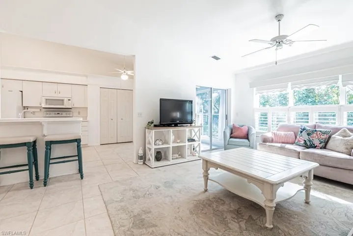 Living room with light tile patterned floors and lofted ceiling