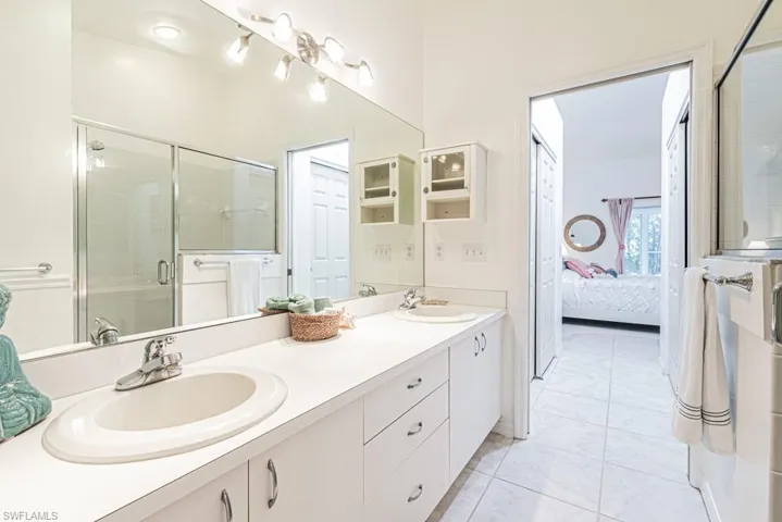 Master Bathroom with tile patterned floors, a shower with door, and vanity