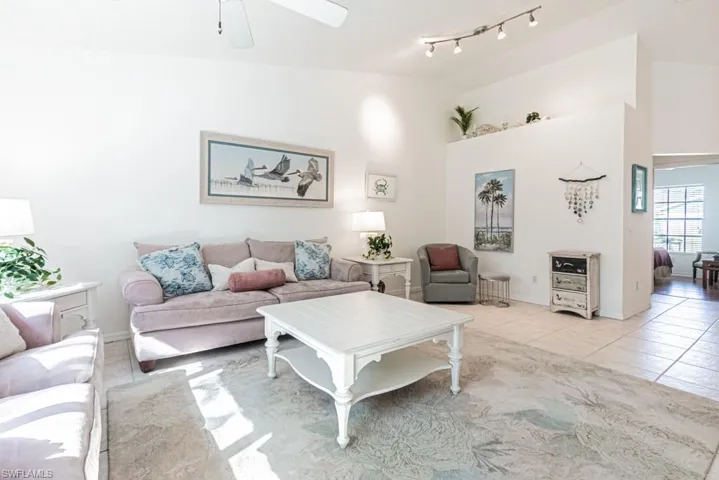 Tiled living room featuring ceiling fan and track lighting