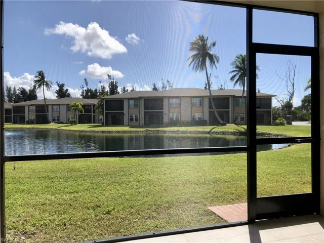 Screened outdoor living area with a dark-framed enclosure, featuring a concrete patio and a wooden-plank accent