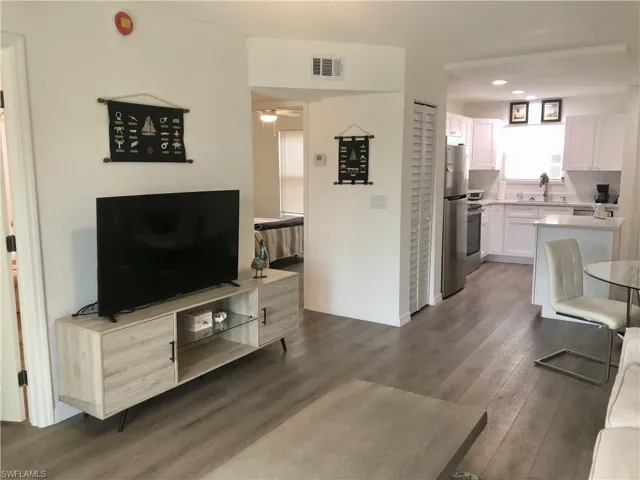 Open-concept living space with wood-finish flooring extending into the kitchen