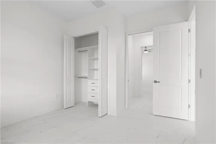 Unfurnished bedroom with light marble finish flooring and a closet
