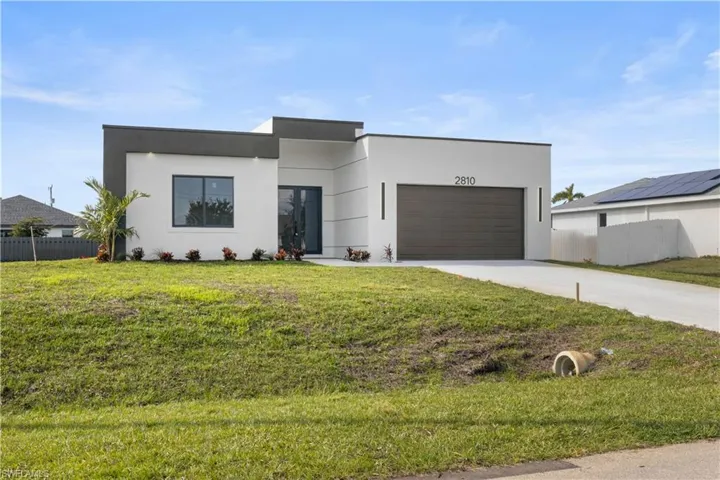 Contemporary home with concrete driveway, stucco siding, and a garage